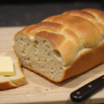 Perfectly baked gluten-free bread, 'El secreto de un Pan Sin Gluten perfecto', sliced and ready to serve.