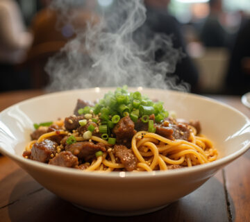 Delicious Chinese beef and vegetable noodles served in a bowl, garnished and ready to enjoy.