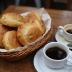 Freshly baked Pan De Bono in a basket with Colombian coffee.