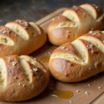 Authentic Pan De Cristal loaves with crispy crust and air pockets, served with olive oil.