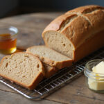 Delicious and easy homemade whole wheat bread slices displayed with honey and butter.