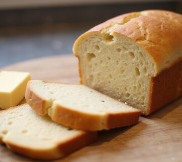 Freshly baked sliced Keto Bread with butter, ready to eat.