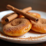Torrijas clásicas servidas en un plato, espolvoreadas con canela y azúcar, listas para disfrutar.