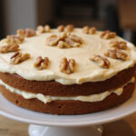 Delicious homemade carrot cake with cream cheese frosting and walnuts for dessert.