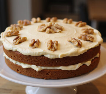 Delicious homemade carrot cake with cream cheese frosting and walnuts for dessert.