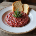 Delicious fuet tartare served with crusty bread, perfect for a Spanish appetizer.