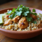 Arroz con pollo de la abuela servido con cilantro fresco y rodajas de lima