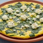 Frittata de espinacas y queso fresco recién hecha, ideal para un desayuno saludable.