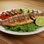 Pescado a la talla terminado, decorado con limones y cilantro, listo para disfrutar.