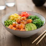 Poke bowl saludable presentado de manera atractiva, preparado con ingredientes frescos y coloridos.