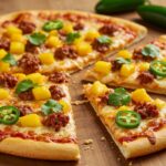 Pizza de mango picante y chorizo terminada, lista para servir en una mesa rústica.