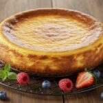 Tarta de queso al horno fácil, decorada con frutas frescas y hojas de menta, ideal para un postre.