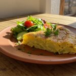 Porción de tortilla de patatas fría en un plato, ideal para degustar en la receta de tortilla de patatas fría.