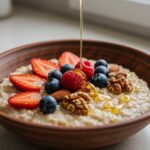 Desayuno de avena nutritivo con clara de huevo, decorado con frutas frescas y miel.