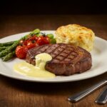 Plato de bistec jugoso con salsa cremosa, ideal para una cena deliciosa.