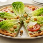 Pizza de ensalada César terminada, perfecta para una comida saludable y fresca.