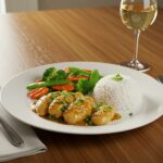 Delicious serving of pollo al limón estilo chino with rice and vegetables for a complete meal.