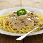 Finished pollo stroganoff served over egg noodles, ready for a delightful meal.