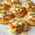 A close-up of golden-brown baked conchas rellenas de carne y ricotta, arranged neatly on a white plate. The shells are glossy and crisp, revealing a glimpse of the creamy ricotta and savory meat filling inside. Garnished with herbs, the image highlights the rich textures and inviting presentation of this Italian baked pasta dish.