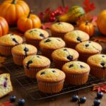 Muffins de arándanos y queso crema recién horneados, ideales para celebraciones de otoño y fiestas.