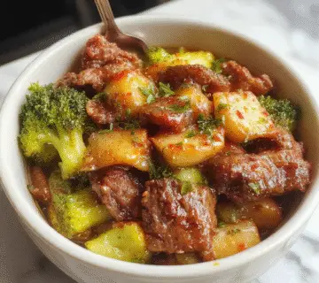 A vibrant dish of Carne de Res y Brócoli Chino served on a white plate. The beef strips are glazed in a glossy dark soy sauce, garnished with fresh green broccoli florets. The presentation highlights the rich, tender meat contrasting with the bright, crisp broccoli, arranged neatly with a sprinkle of sesame seeds and chopped green onions for a colorful touch. In the background, a pair of chopsticks rests beside the plate, evoking an authentic Chinese cuisine vibe.